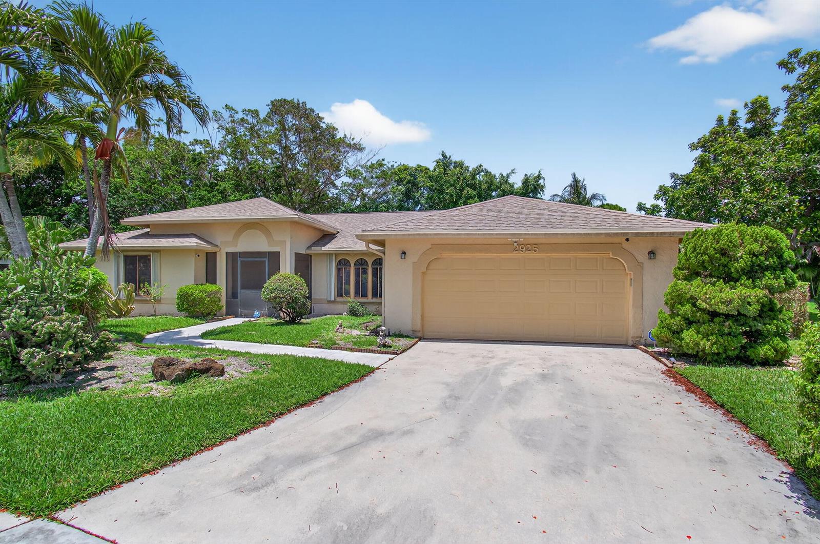 A single-story house with a beige stucco exterior, a two-car garage, and a palm tree — 2925 Riviera Drive, Delray Beach FL 33445, DELRAY BEACH, FL