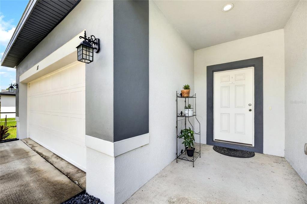A white front door and garage entrance are visible on the exterior of a house — 217 BEGONIA LANE, POINCIANA, FL