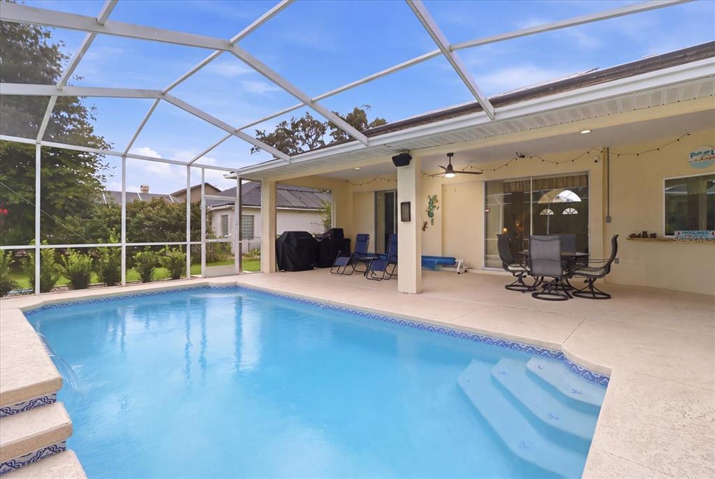 A screened-in patio features a swimming pool with steps and outdoor dining furniture — 3843 W NORTHCREST COURT, LECANTO, FL