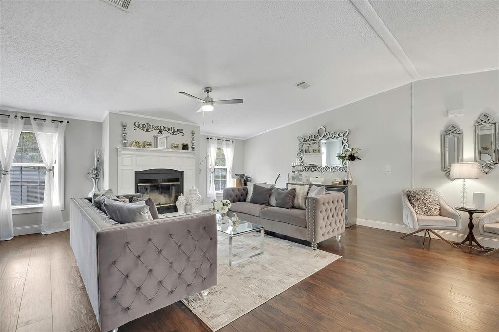 A living room features two tufted grey sofas, a fireplace, and dark wood flooring — 6171 S LISA POINT, HOMOSASSA, FL
