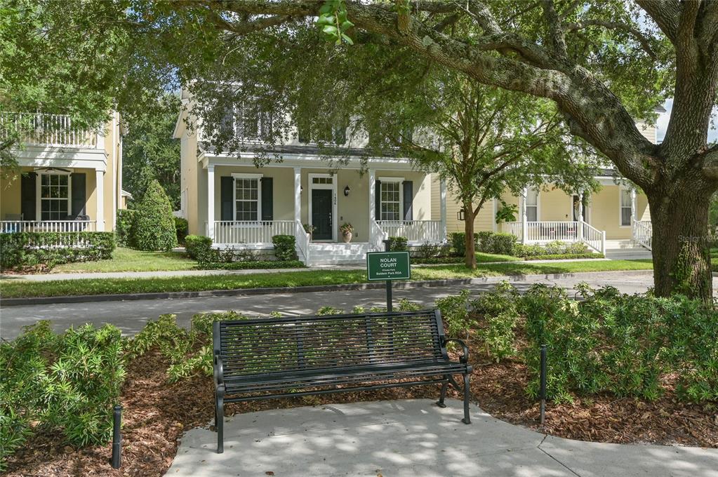 A black metal bench sits on a concrete path in front of a suburban house — 1406 NOLAN COURT, ORLANDO, FL