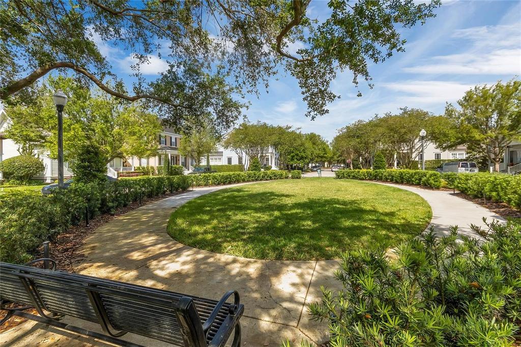 A circular grassy park area is surrounded by a concrete walkway, hedges, and residential homes — 1406 NOLAN COURT, ORLANDO, FL