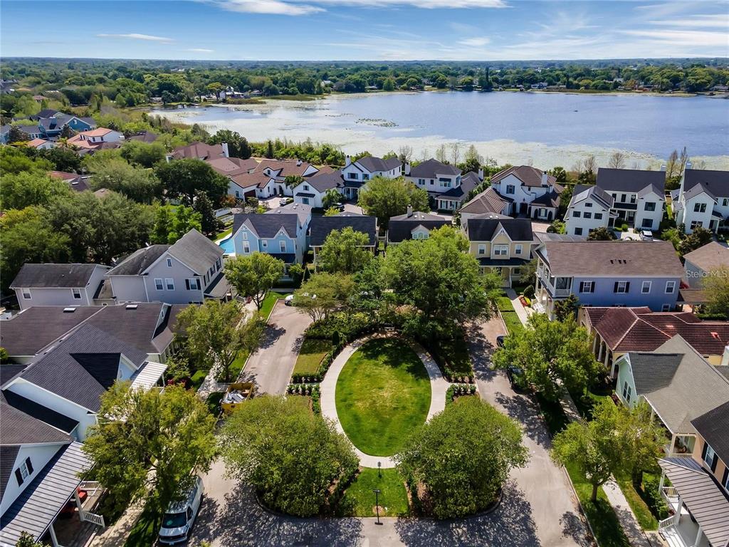 An aerial view shows a residential neighborhood with houses surrounding a central oval park — 1406 NOLAN COURT, ORLANDO, FL