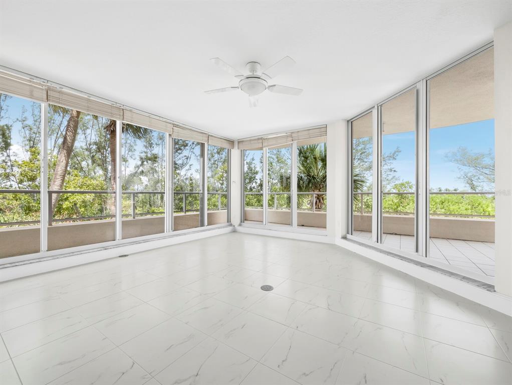 A bright, open-concept living area features white tile flooring, white walls, and floor-to-ceiling windows — 3080 GRAND BAY BOULEVARD UNIT 512, LONGBOAT KEY, FL