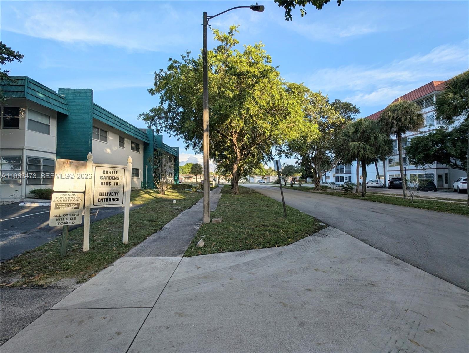 A street view shows a residential building with a parking sign and delivery entrance sign — 4801 NW 22nd Ct # 205, Lauderhill FL 33313, LAUDERHILL, FL