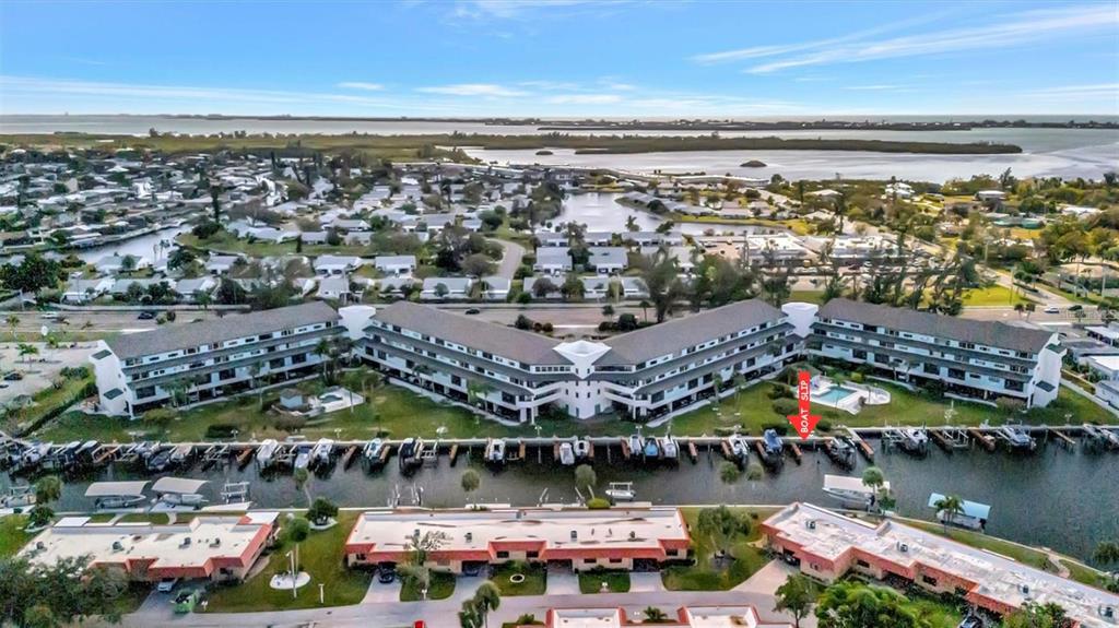 An aerial view shows a multi-story apartment complex with a boat dock and swimming pool — 9604 CORTEZ ROAD W UNIT 334, BRADENTON, FL