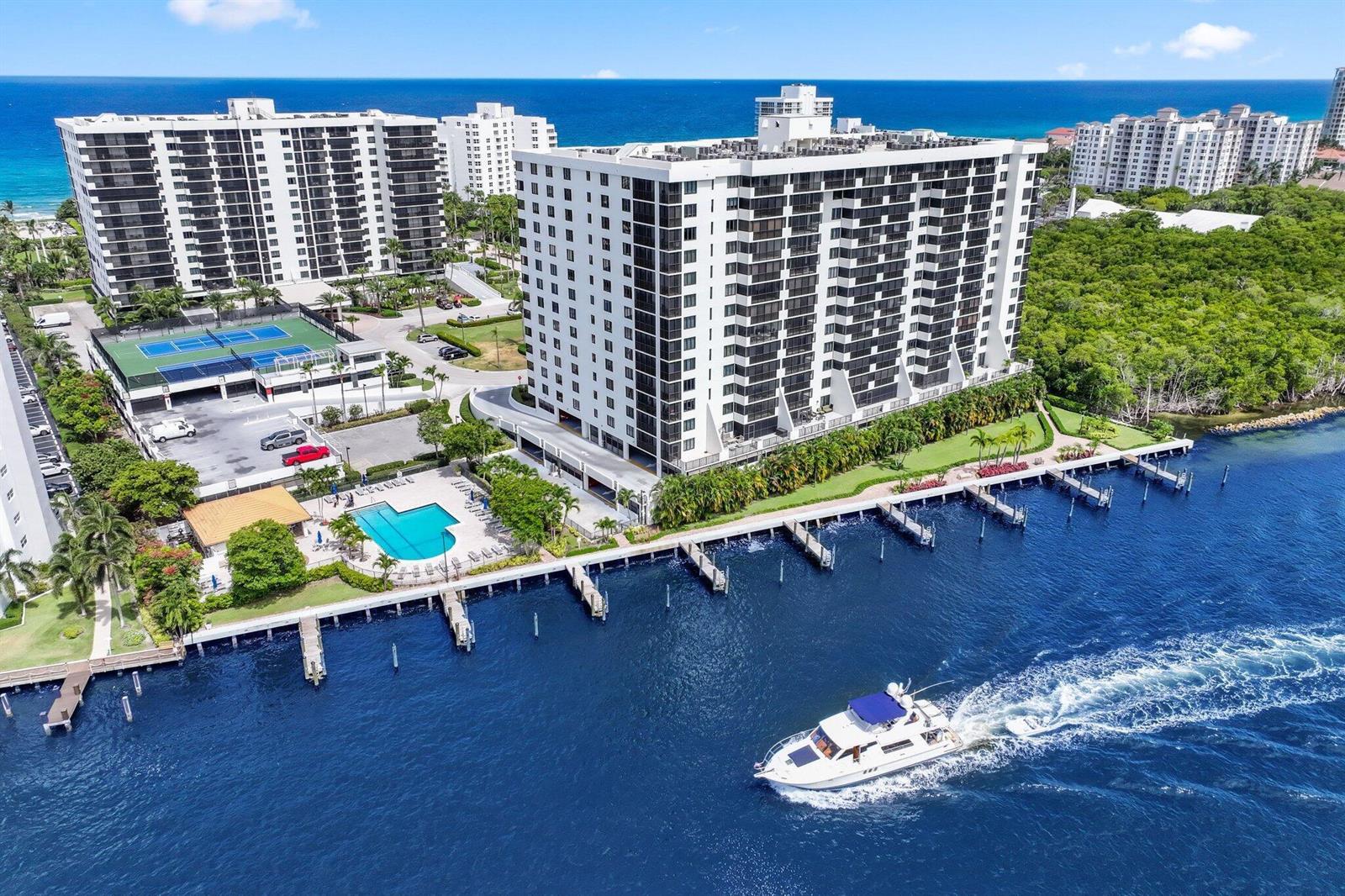An aerial view shows a white high-rise condominium building with a pool, tennis courts, and docks — 3420 S Ocean Boulevard # 4z, Highland Beach FL 33487, HIGHLAND BEACH, FL