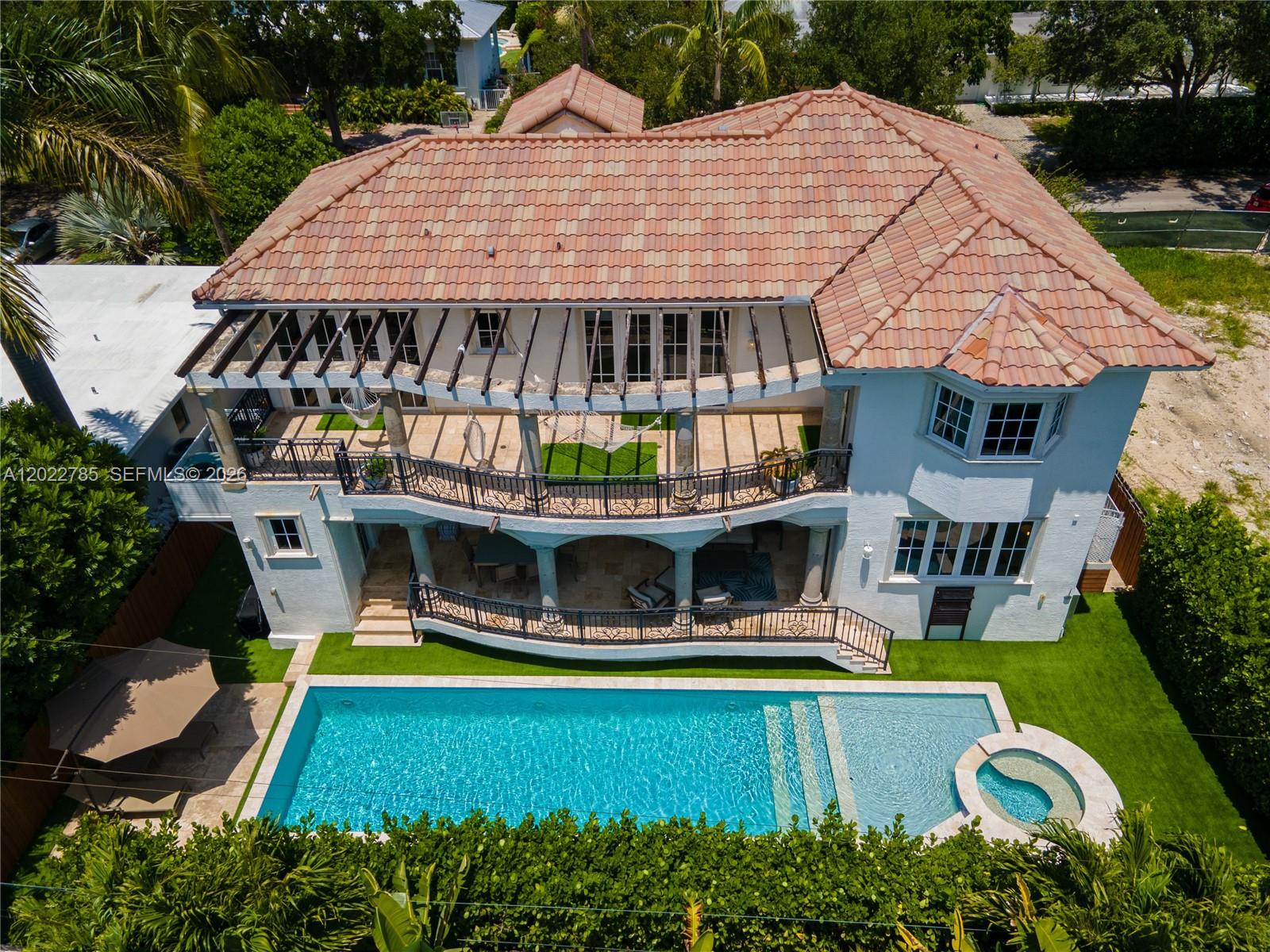 An aerial view of a two-story house with a tiled roof, balconies, and a swimming pool — 350 Redwood Ln, Key Biscayne FL 33149, KEY BISCAYNE, FL