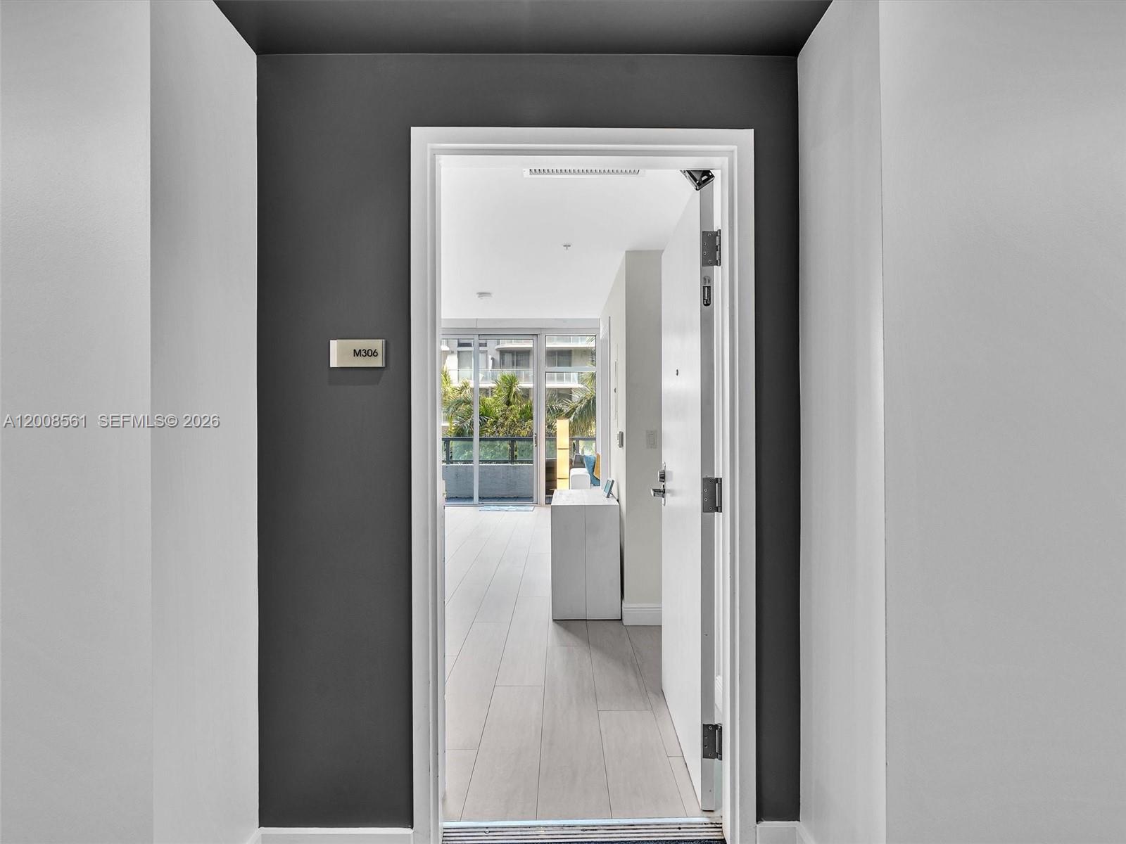 A doorway with a room number sign opens into a bright apartment with light flooring — 3301 NE 1st Ave # M0306, Miami FL 33137, MIAMI, FL