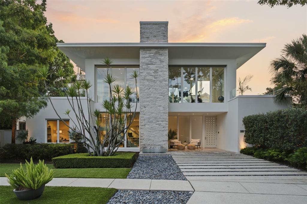 A modern two-story house features a stone chimney, large windows, and a landscaped front yard — 229 ALEXANDER PLACE, WINTER PARK, FL