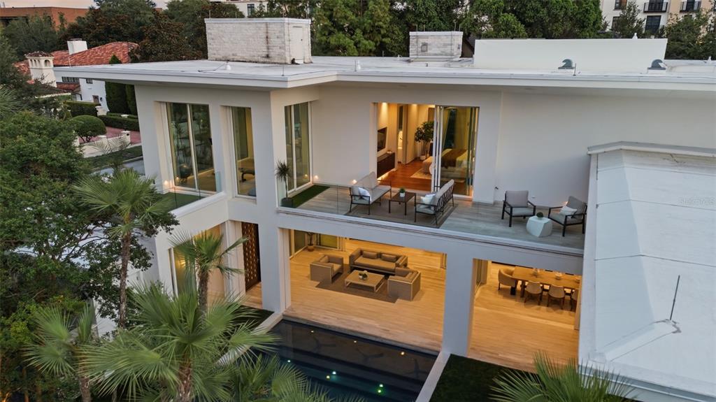 An aerial view of a modern two-story house with a pool, patio, and balcony — 229 ALEXANDER PLACE, WINTER PARK, FL