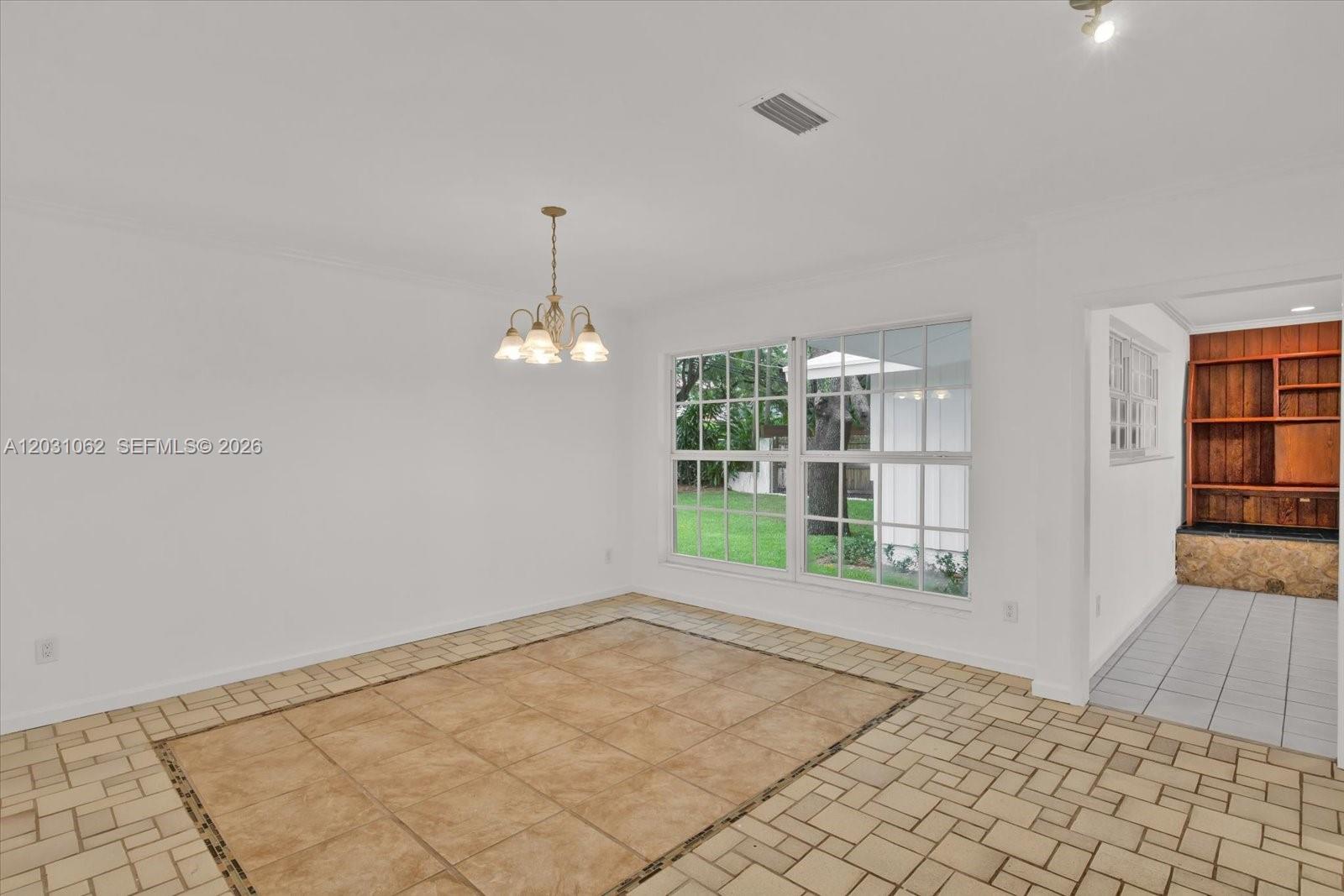 A dining area features a tile floor, a chandelier, and a view of the backyard — 2850 Natoma St # 0, Miami FL 33133, MIAMI, FL