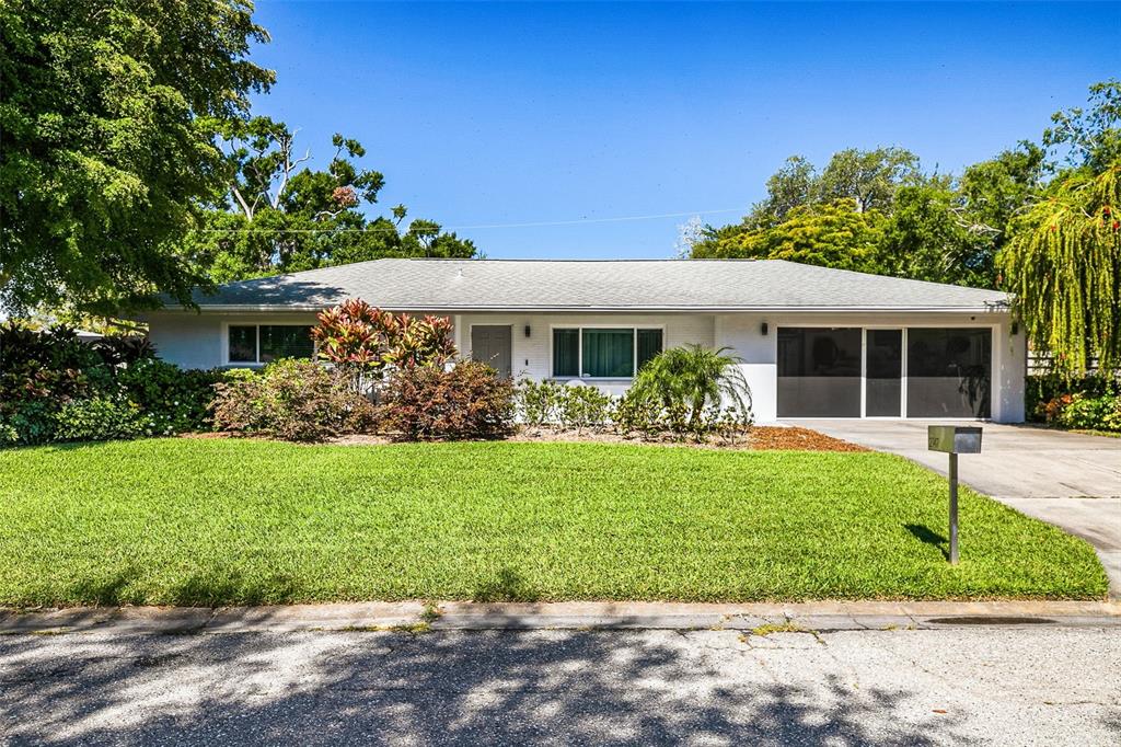 A single-story white house with a gray roof, front lawn, and attached garage — 2747 JEFFERSON CIRCLE, SARASOTA, FL