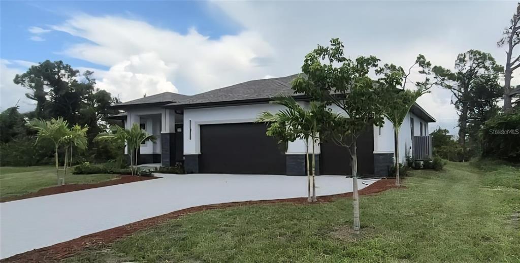 A modern single-story house with a two-car garage and a paved driveway — 47 BRIG CIRCLE E, PLACIDA, FL