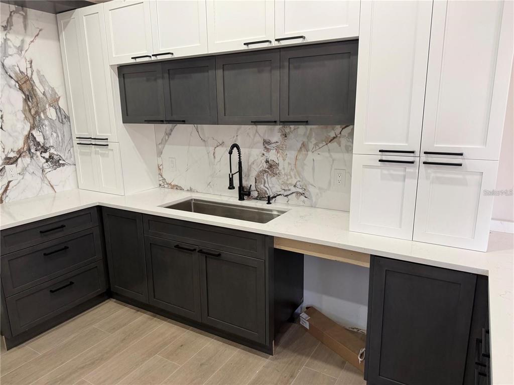 A modern bathroom features a floating wood vanity, dual sinks, and large rectangular mirrors — 47 BRIG CIRCLE E, PLACIDA, FL