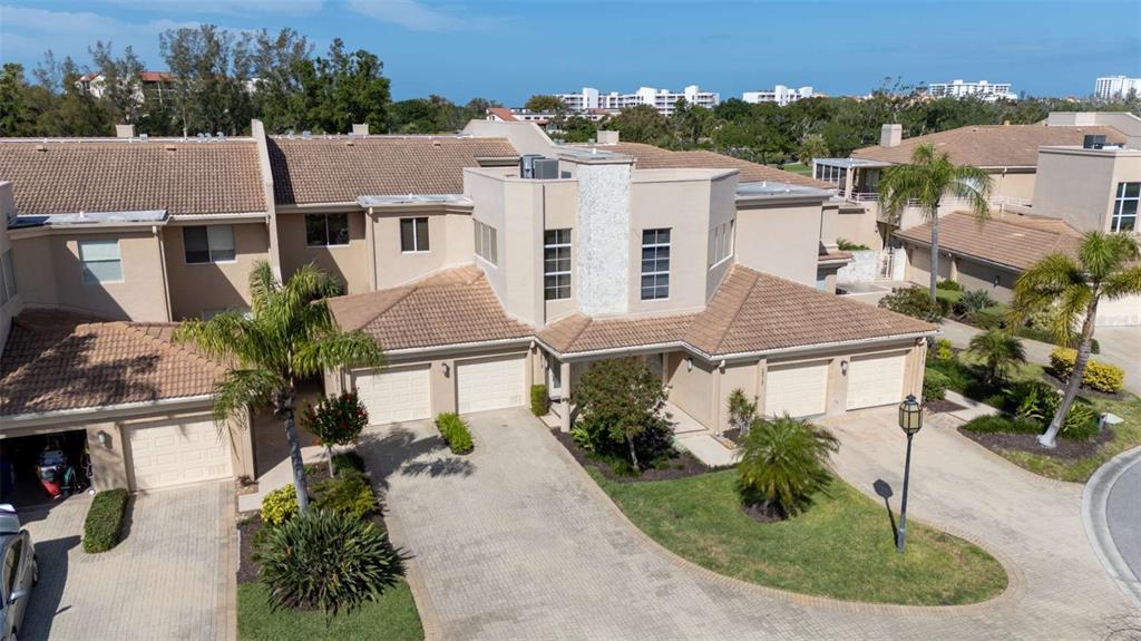 An aerial view of a multi-unit townhouse complex with beige stucco walls and tiled roofs — 2013 HARBOUR LINKS DRIVE UNIT 2013, LONGBOAT KEY, FL