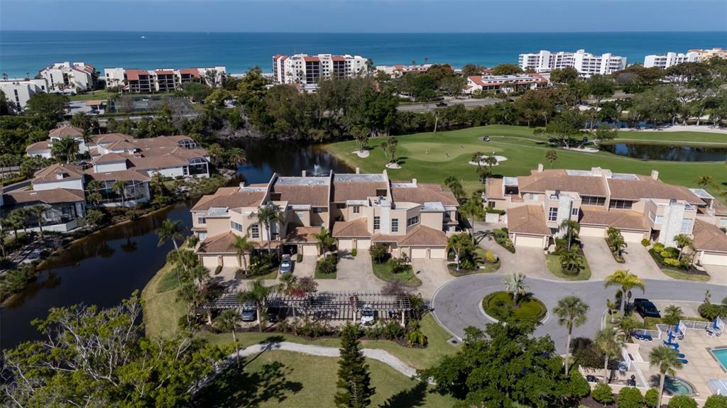 An aerial view of a residential complex with townhomes, a golf course, and the ocean — 2013 HARBOUR LINKS DRIVE UNIT 2013, LONGBOAT KEY, FL