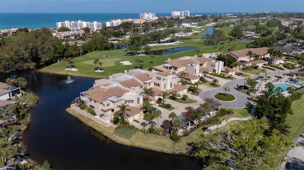 An aerial view of a multi-story residential complex situated beside a lake and golf course — 2013 HARBOUR LINKS DRIVE UNIT 2013, LONGBOAT KEY, FL