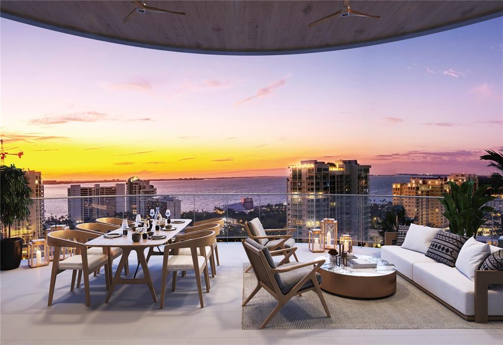 This rendering shows a luxury balcony with outdoor dining and lounge furniture overlooking a sunset — 290 COCOANUT AVENUE UNIT 601, SARASOTA, FL