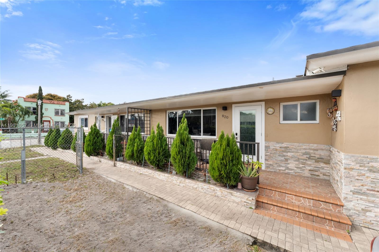A single-story house exterior features a stone-accented facade, a front porch, and manicured evergreen shrubs — 820 SW 17th Ave # 1, Miami FL 33135, MIAMI, FL