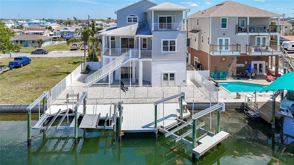 An aerial view of a multi-story waterfront house with a private dock and swimming pool — 13737 VICTOR AVENUE, HUDSON, FL