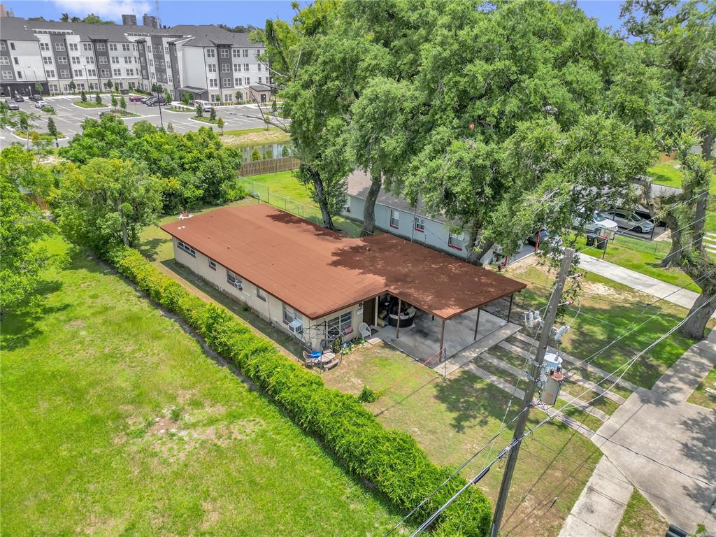 An aerial view shows a single-story house with a brown roof and attached carport — 1113 S LEE AVENUE, ORLANDO, FL