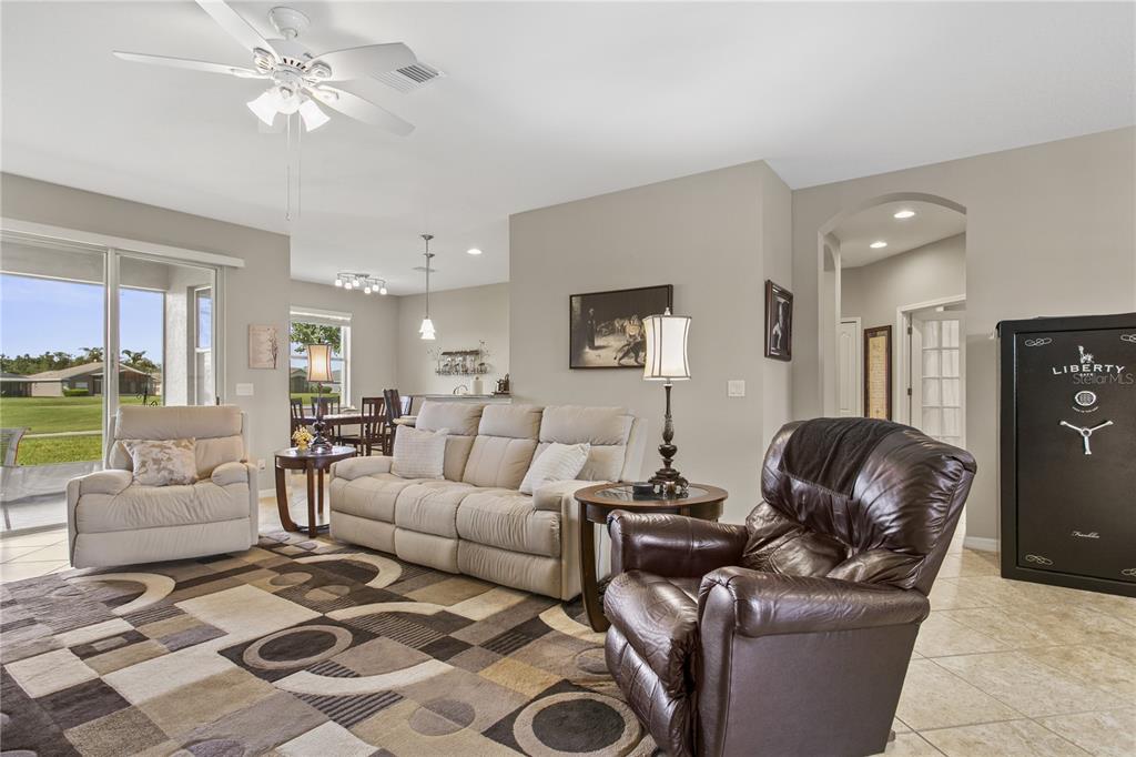 A living room features a beige sofa, a brown leather recliner, and a large safe — 29255 GRASS BUNKER DRIVE, SAN ANTONIO, FL