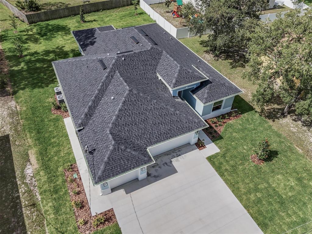 An aerial view shows a single-story house with a dark shingled roof and concrete driveway — 14 WHITE BIRCH LANE, PALM COAST, FL