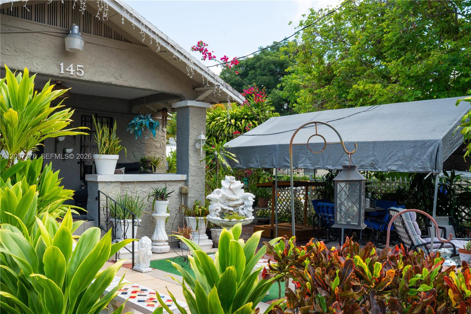 A house exterior features a front porch, a gray canopy, and various potted plants — 145 NW 31st St, Miami FL 33127, MIAMI, FL