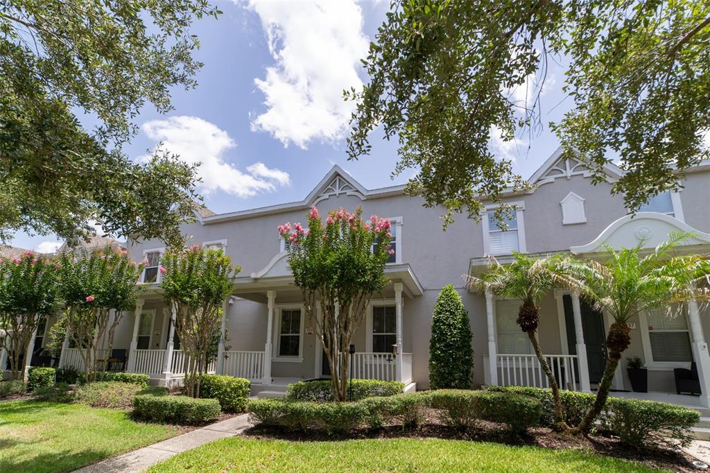 A row of two-story townhouses with gray siding, white porches, and manicured landscaping — 3933 CLEARY WAY, ORLANDO, FL