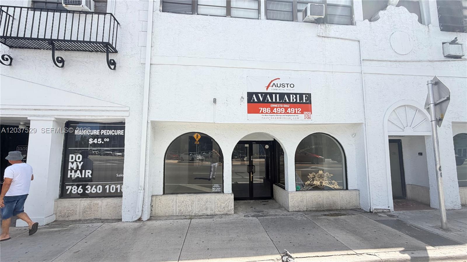 The exterior of a white commercial building features arched windows and a large available sign — 2614 SW 8th St # 2610, Miami FL 33135, MIAMI, FL