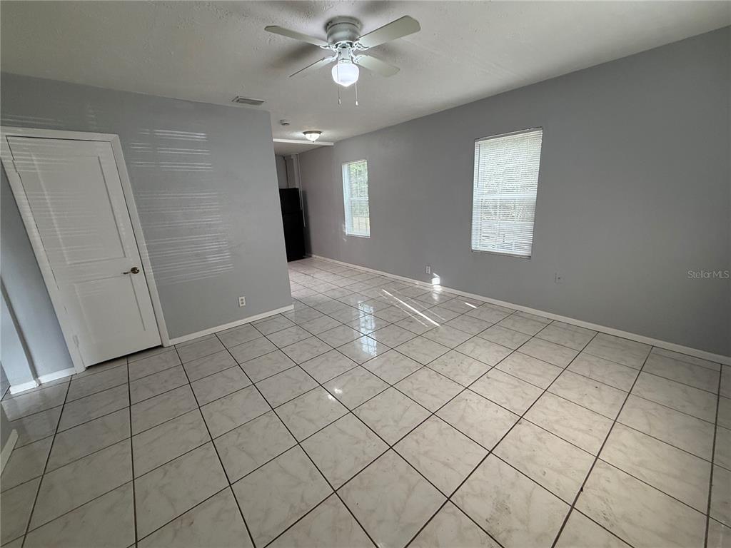A room with light gray walls, white tile flooring, a ceiling fan, and two windows — 2705 6TH STREET W, BRADENTON, FL