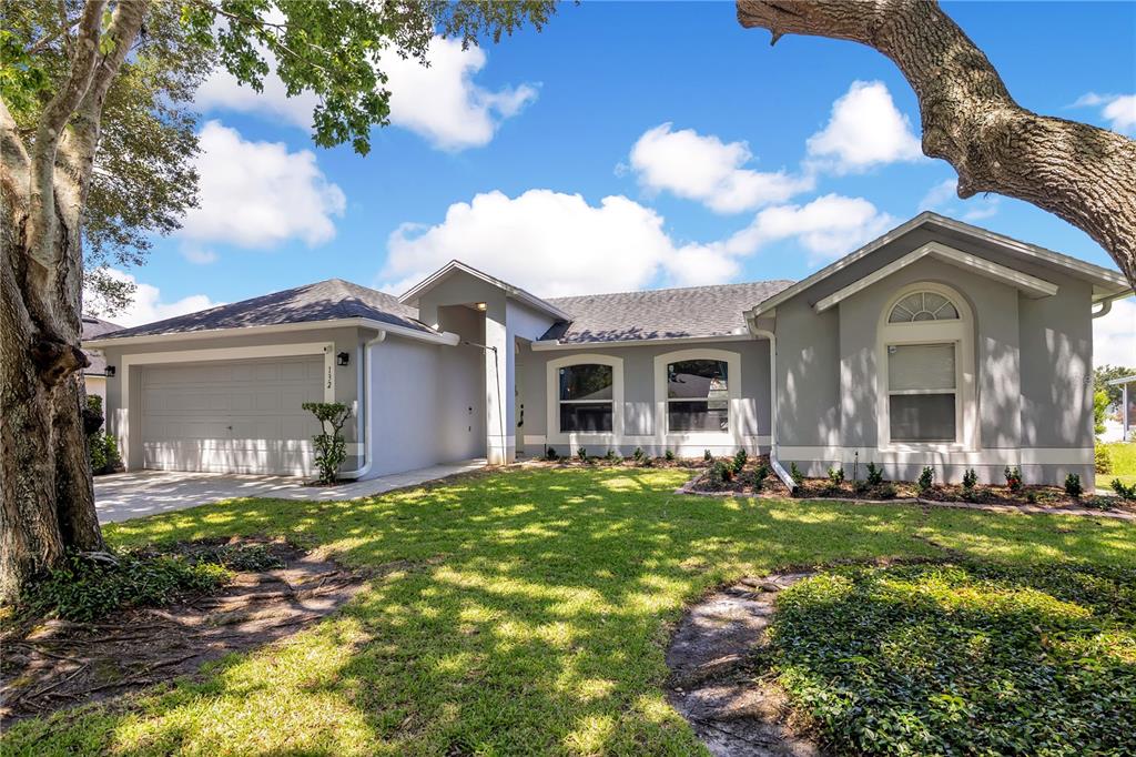 A backyard view of a house with a screened-in patio and a white fence — 132 ZACHARY WADE STREET, WINTER GARDEN, FL