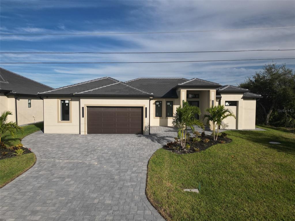 A single-story house with a brown garage door, tiled roof, and a paved driveway — 10474 WINNIPEG STREET, PORT CHARLOTTE, FL