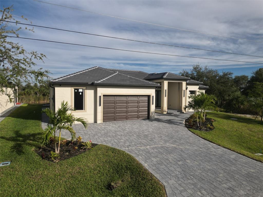 A single-story house with a tiled roof, a two-car garage, and a paved driveway — 10474 WINNIPEG STREET, PORT CHARLOTTE, FL