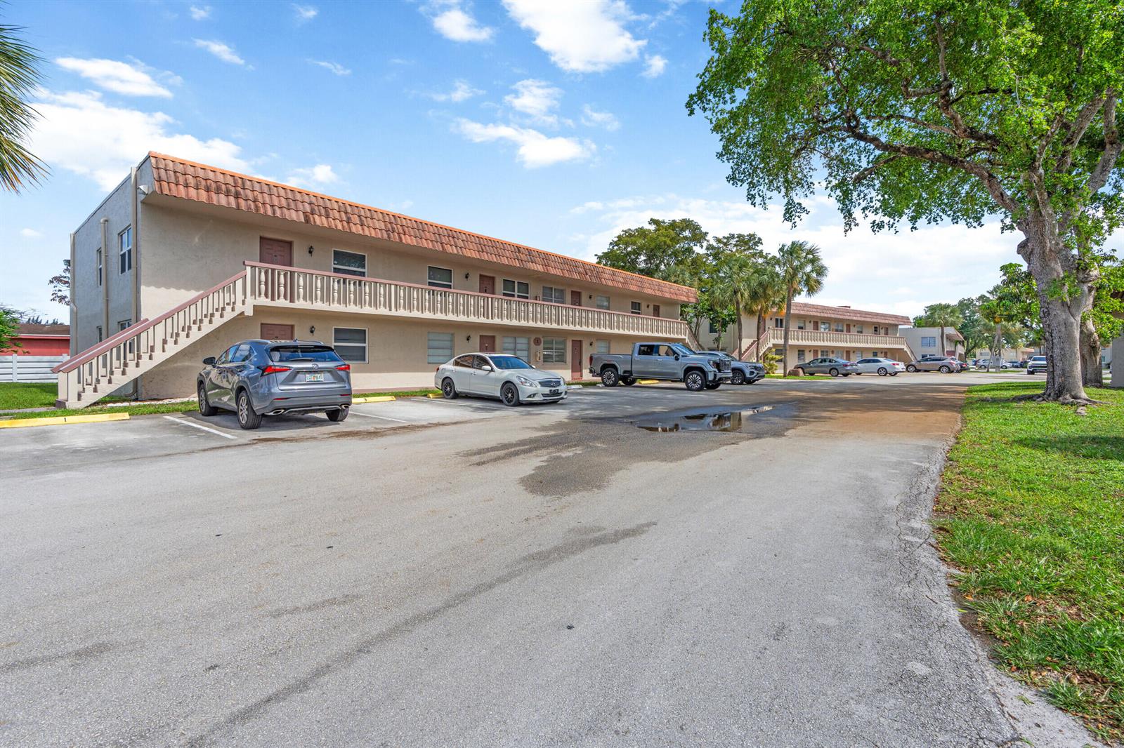 A two-story apartment building with a balcony and parking lot under a blue sky — 3777 NW 78th Avenue # 1b, Davie FL 33024, DAVIE, FL