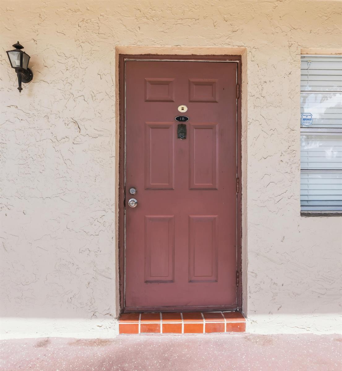 A brown front door with a knocker and unit number 1B on a stucco exterior — 3777 NW 78th Avenue # 1b, Davie FL 33024, DAVIE, FL