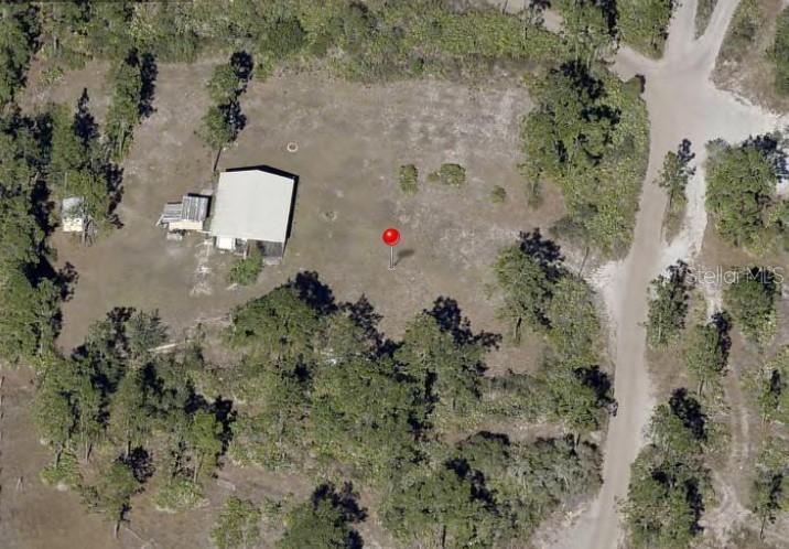 An aerial view shows a house and a small shed on a wooded lot — HOLOPAW GROVES ROAD, ST CLOUD, FL
