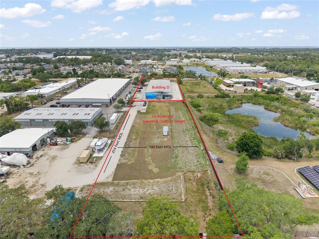This aerial view shows an industrial property with a building and a large outdoor storage area — 1500 L AND R INDUSTRIAL BOULEVARD Bldg. D, TARPON SPRINGS, FL