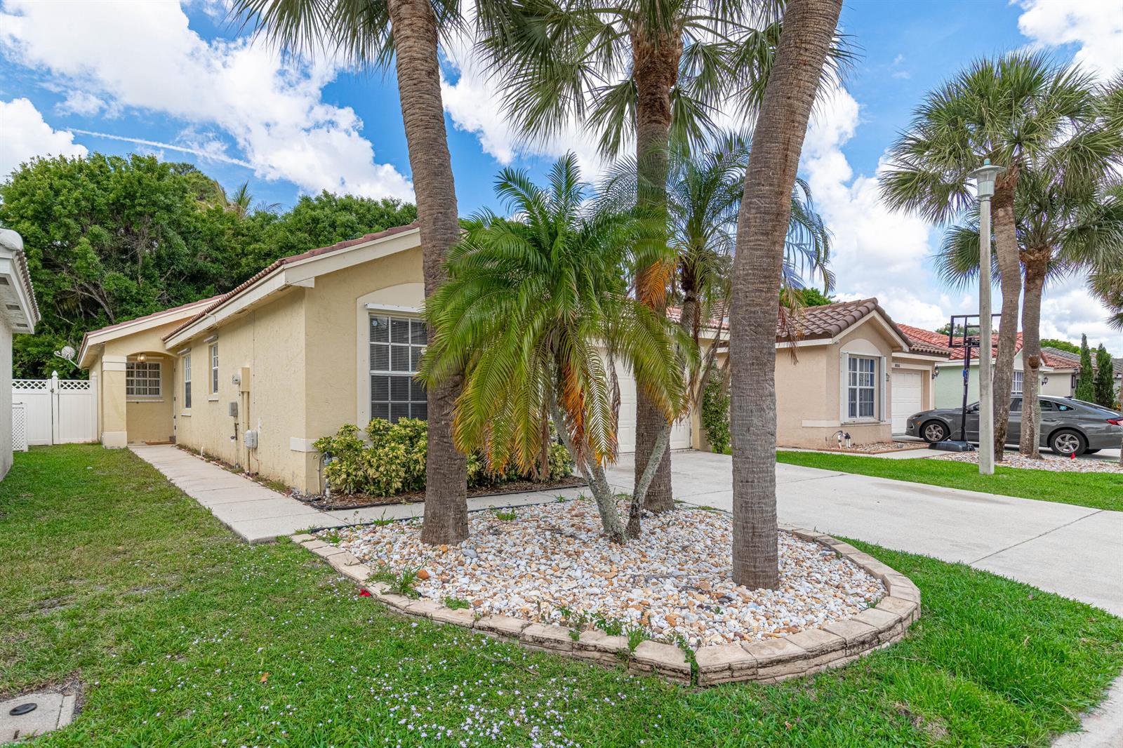 A single-story house with a palm tree-filled rock garden in the front yard — 8057 Stirrup Cay Court, Boynton Beach FL 33436, BOYNTON BEACH, FL