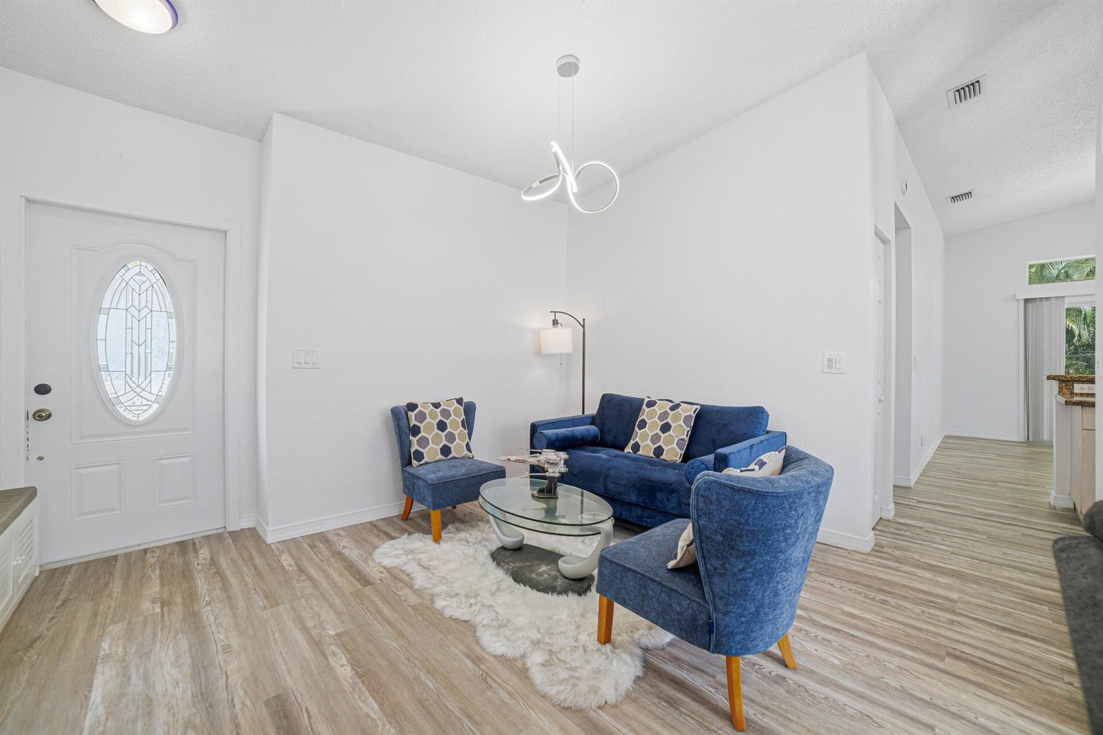 A living area features blue furniture, a glass coffee table, and a white rug — 8057 Stirrup Cay Court, Boynton Beach FL 33436, BOYNTON BEACH, FL
