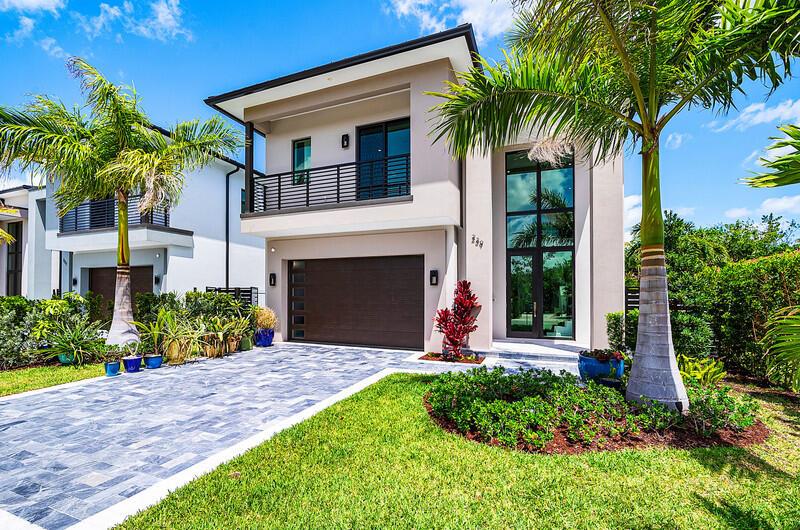 A modern two-story house with a paved driveway, a garage, and palm trees — 239 NE 11th Street, Delray Beach FL 33444, DELRAY BEACH, FL