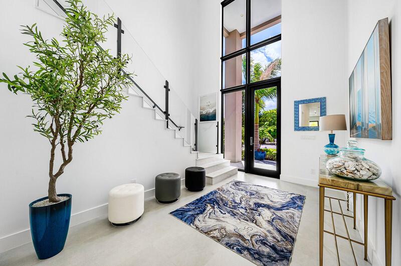 A bright entryway features a staircase, a tall potted tree, and a blue patterned rug — 239 NE 11th Street, Delray Beach FL 33444, DELRAY BEACH, FL