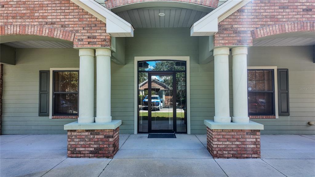 The exterior entrance features a glass door flanked by double columns on brick pedestals — 3235 SW 34TH STREET UNIT 102, OCALA, FL