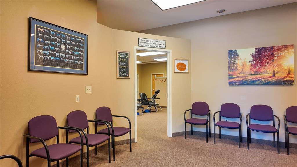 A waiting room features purple chairs, framed wall art, and a doorway leading to another room — 3235 SW 34TH STREET UNIT 102, OCALA, FL
