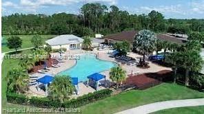 An aerial view of a community swimming pool with lounge chairs and blue cabanas — 6868 Pinta Drive, Sebring FL 33872, SEBRING, FL