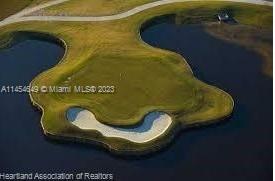An aerial view of a golf course island green surrounded by water and a sand bunker — 6868 Pinta Drive, Sebring FL 33872, SEBRING, FL