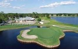 An aerial view shows a golf course green surrounded by water near a clubhouse building — 6868 Pinta Drive, Sebring FL 33872, SEBRING, FL