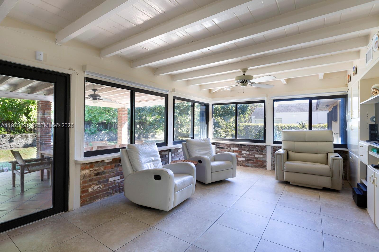 A sunroom features tile floors, exposed ceiling beams, brick walls, and three white recliners — 3721 SW 58th Ave, Miami FL 33155, MIAMI, FL