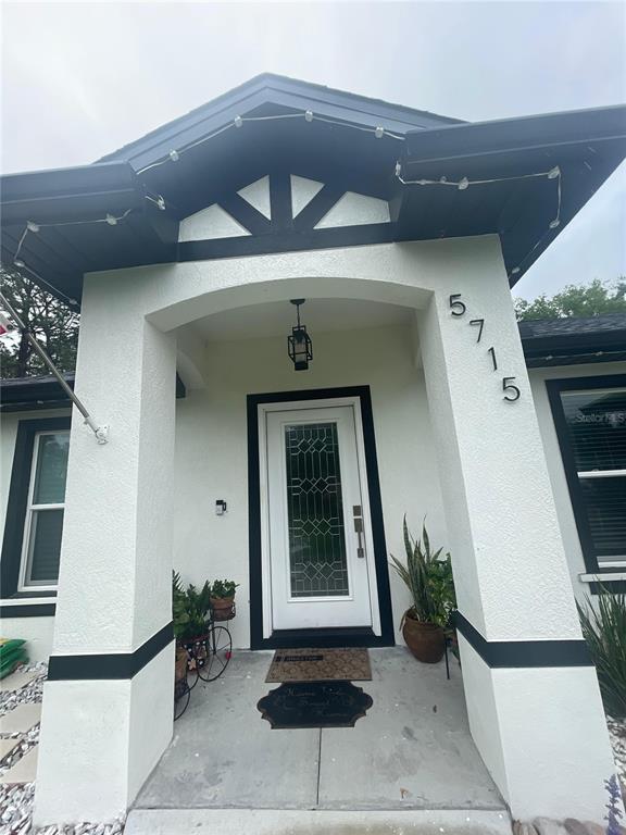 The front entrance of a house features a white door with glass panels and columns — 5715 SW 128TH PLACE, OCALA, FL